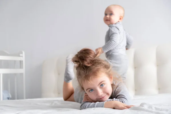 Menino e menina irmã se divertindo em casa na cama. Atividades domésticas para crianças. — Fotografia de Stock