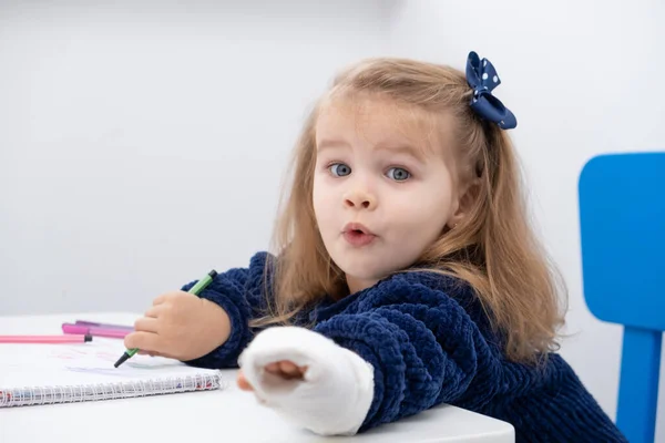 Маленькая Девочка Рукой Гипсе Сидит Столом Пытаясь Рисовать Маркерами — стоковое фото