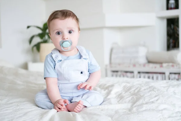 Bambino Mesi Con Capezzolo Abiti Blu Seduto Sul Letto Bianco — Foto Stock