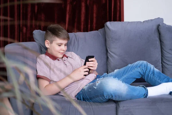 Junge Hübsche Teenager Gucken Medieninhalte Smartphone Auf Grauem Sofa Hause — Stockfoto