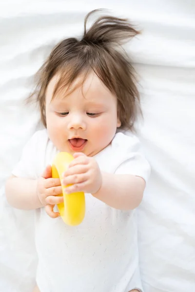 Lindo Bebé Niño Acostado Cama Jugar Con Amarillo Plástico Círculo — Foto de Stock