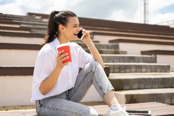 Счастливая Девочка Подросток Разговаривает Телефону Держа Чашку Кофе Руке Наслаждаясь — стоковое фото