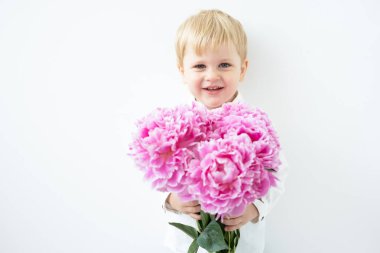 Beyaz arka planda pembe şakayık demeti olan sarışın çocuk. Aşk ve romantik konsept.