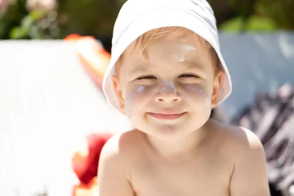 Proteção solar. close up retrato de rosto de menino sorridente com protetor solar — Fotografia de Stock