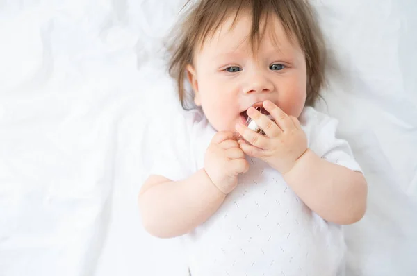 Menino bonito 6 meses com mamilo deitado em uma cama branca em casa. vista superior. — Fotografia de Stock