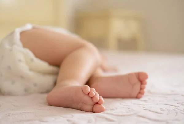 Close up baby legs lying on bed at home — Stock Photo, Image