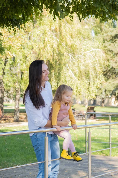 stock image adult woman having fun with her child daughter in green park.