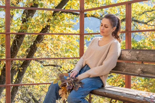 Kazaklı, mutlu, orta yaşlı bir kadın elinde renkli yapraklardan bir buket tutuyor. sonbahar sezonu. — Stok fotoğraf