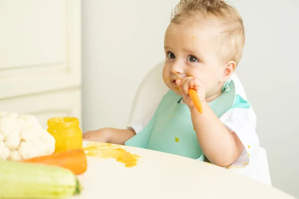 Divertido Bebé Niño Babero Comer Puré Verduras Con Cuchara Sentado Fotos De Stock Sin Royalties Gratis