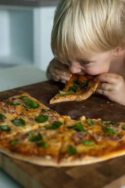 Evde yemek yiyen tatlı çocuk evde pizza yapmış..