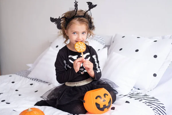 Gyönyörű Kislány Boszorkány Jelmezben Eszik Cookie Kat Díszített Halloween Hálószoba — Stock Fotó