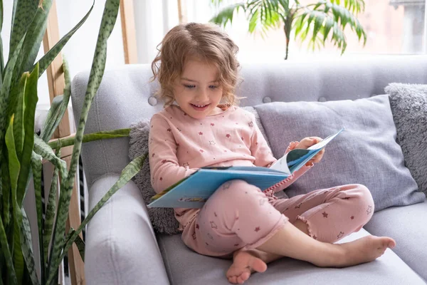Bela Criança Pequena Menina Caucasiana Feliz Pijama Leitura Livro Sentado — Fotografia de Stock