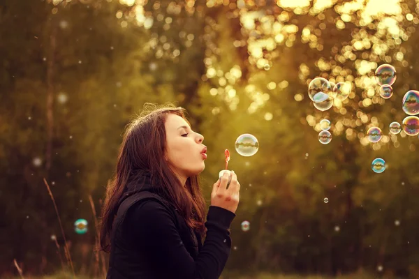 Jeune fille soufflant bulles de savon . — Photo