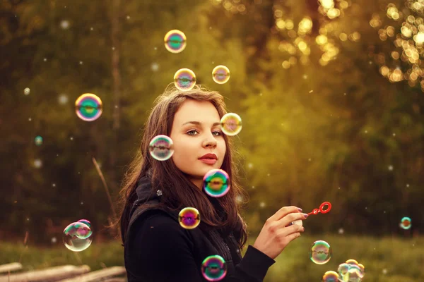 Молода дівчина дме мильні бульбашки . — стокове фото