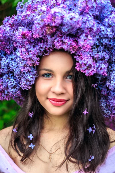 Beautiful young girl in a wreath of lilac. — Stock Photo, Image