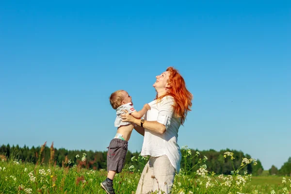 Güzel kızıl saçlı anne bebeği ile oynamak. — Stok fotoğraf