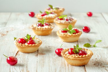 Krem şanti ve kiraz ile tartlets.