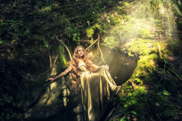 Beautiful girl with long hair in a mystical forest.