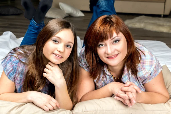 Mother with her daughter lying on the bed. — Stock Photo, Image