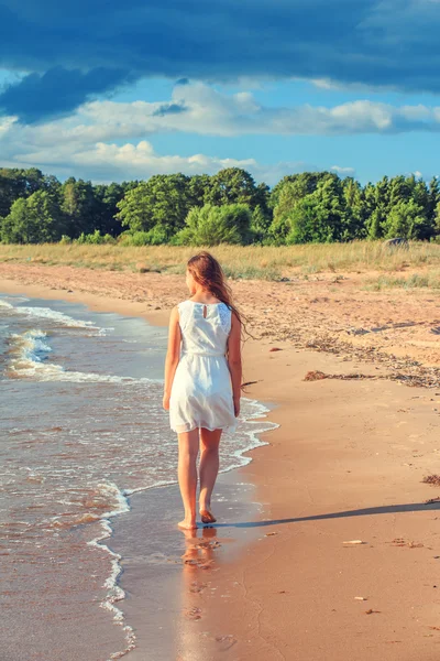 Dívka chodí podél pobřeží. — Stock fotografie