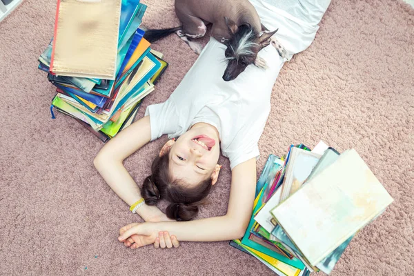Menina Caucasiana Está Brincando Com Cachorro Chão Muitos Livros Sua — Fotografia de Stock