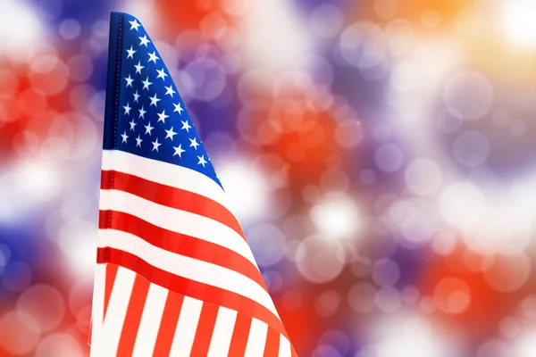 American flag on a background of colored bokeh of white, blue and red colors. For the Independence Day of the United States.