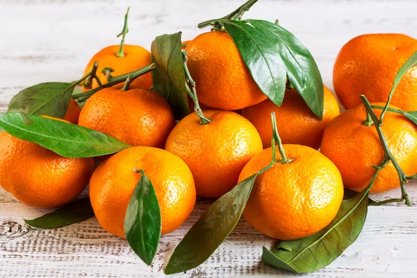 Tangerines with leaves on a wooden table — Stock Photo, Image