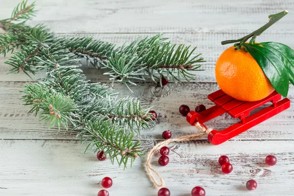 Tangerine with leaves on a red sled — Stock Photo, Image