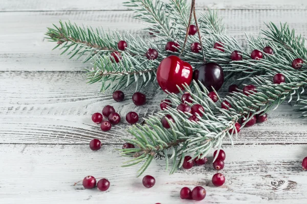 Cranberries, cherries and Christmas tree branches on a wooden ta — Stock Photo, Image