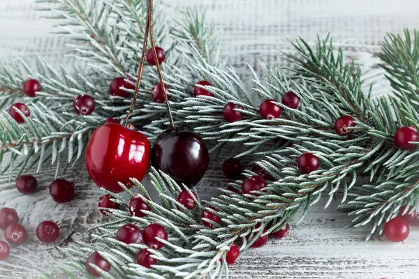 Cranberries, cherries and Christmas tree branches on a wooden ta — Stock Photo, Image