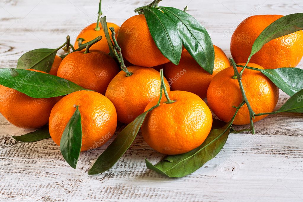 Tangerines with leaves on a wooden table — Stock Photo