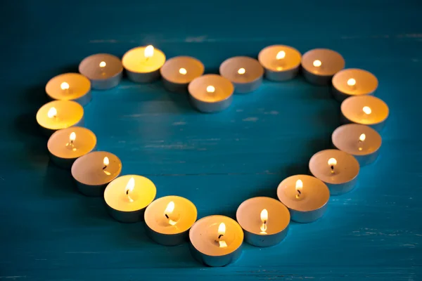 Le coeur des bougies sur un fond bleu — Photo