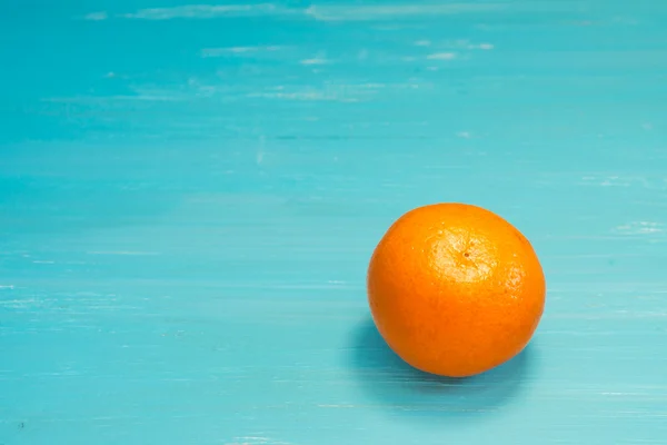 Juicy tangerine on a blue wooden background — Stock Photo, Image