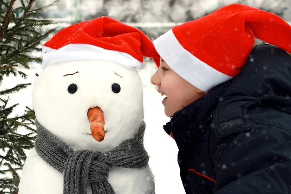 Junge und Schneemann — Stockfoto