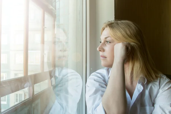 La donna smarrita nel pensiero guardando fuori dalla finestra . — Foto Stock