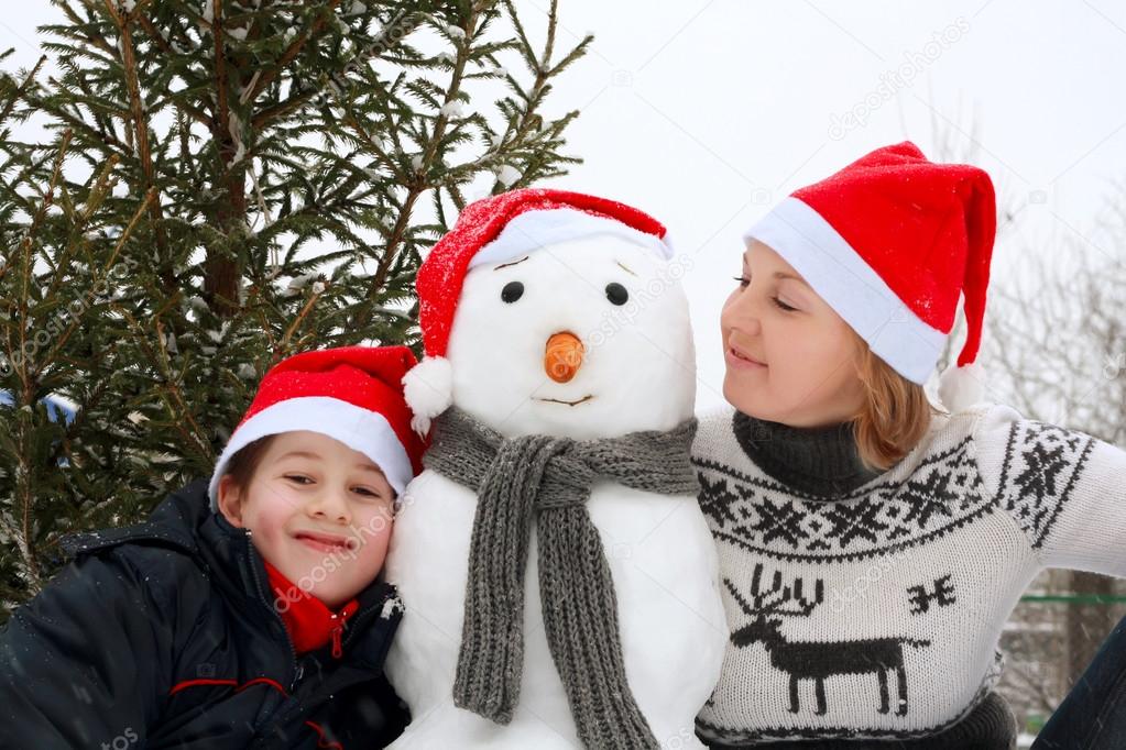 Mother and son playing snowman. 