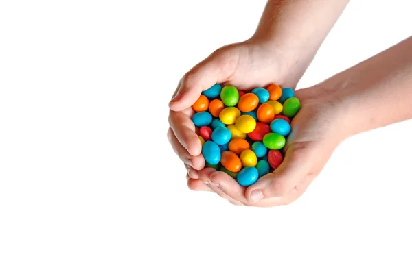 Mani dei bambini che tengono caramelle colorate. — Foto Stock