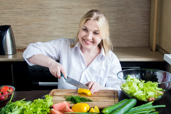 Giovane donna trita le verdure in cucina . — Foto Stock