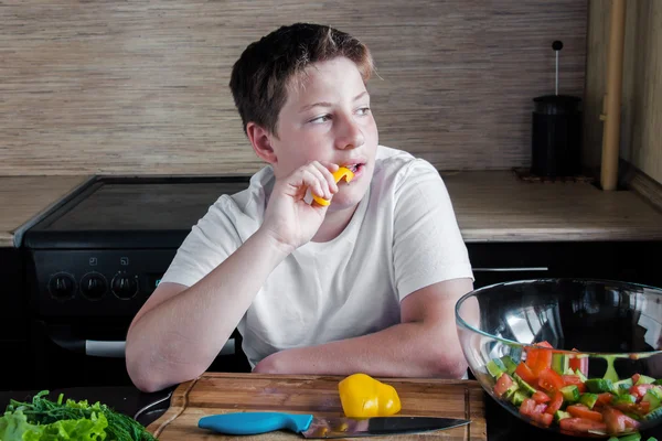 Junge bereitet Salat in der Küche zu. — Stockfoto