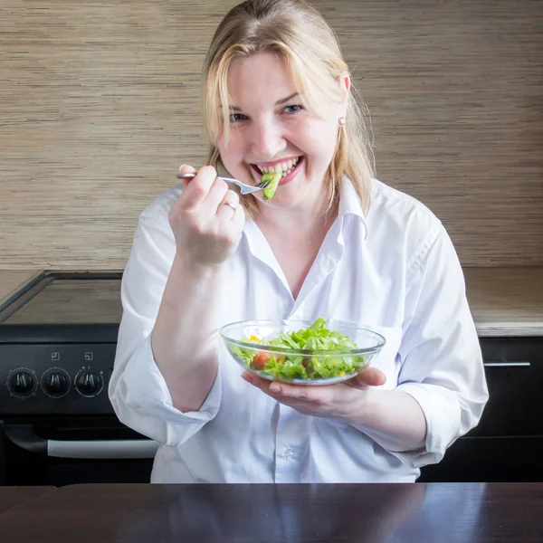 Mujer joven comiendo ensalada y divirtiéndose . — Foto de Stock