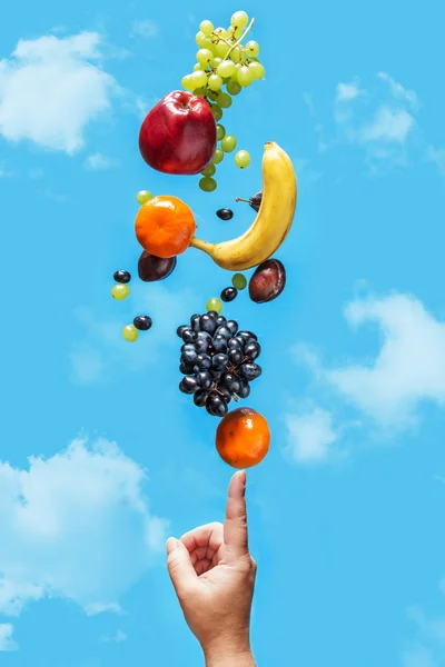 Fresh fruit balancing on a human hand. — Stock Photo, Image