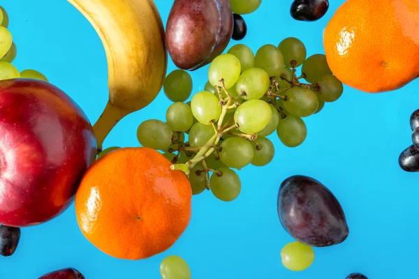 Frutas frescas sobre fondo azul. — Foto de Stock