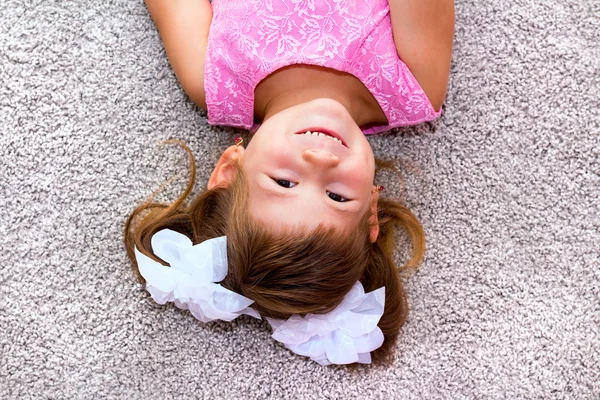 Klein meisje liggend op de vloer. — Stockfoto