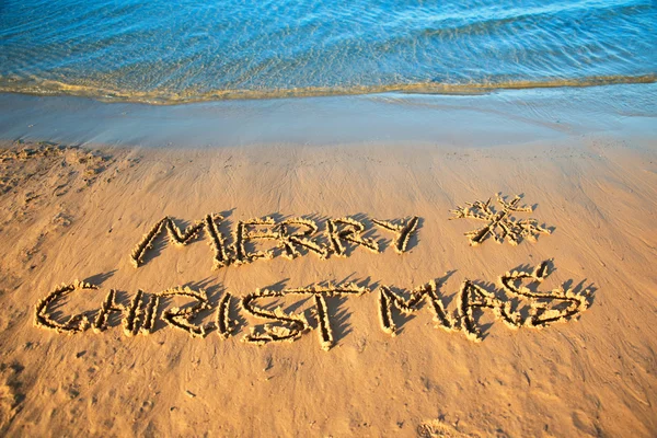 A inscrição "Feliz Natal" na areia . — Fotografia de Stock