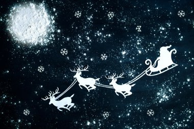 Noel Baba ve gece gökyüzüne uçan Ren geyiği.