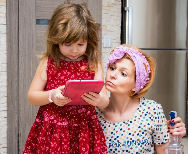 Niña y su madre mirando la pantalla del gadget . —  Fotos de Stock