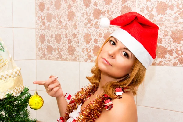 Schöne Frau schmückt einen Weihnachtsbaum. — Stockfoto