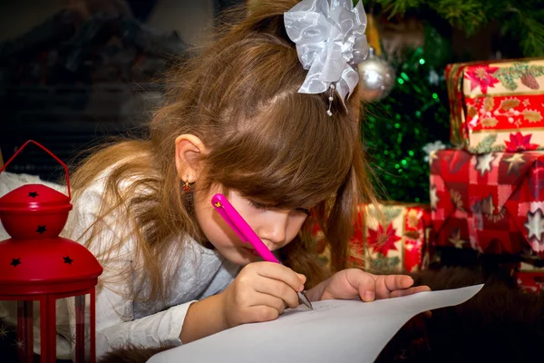 Pequena menina bonita escreve uma carta para Santa . — Fotografia de Stock