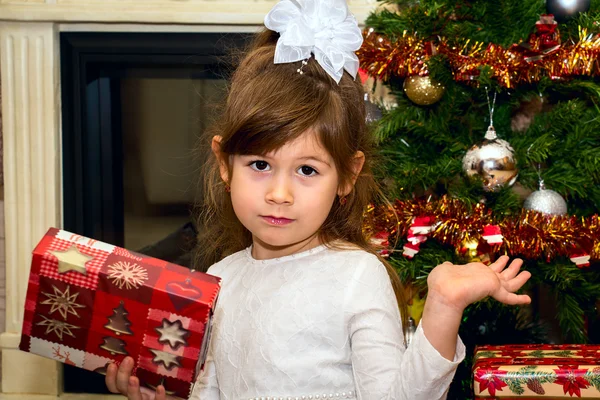 Lilla vackra flicka håller en gåva. — Stockfoto