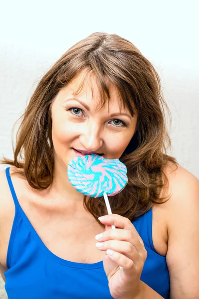 Beautiful middle-aged woman holding a lollipop. — Stock Photo, Image